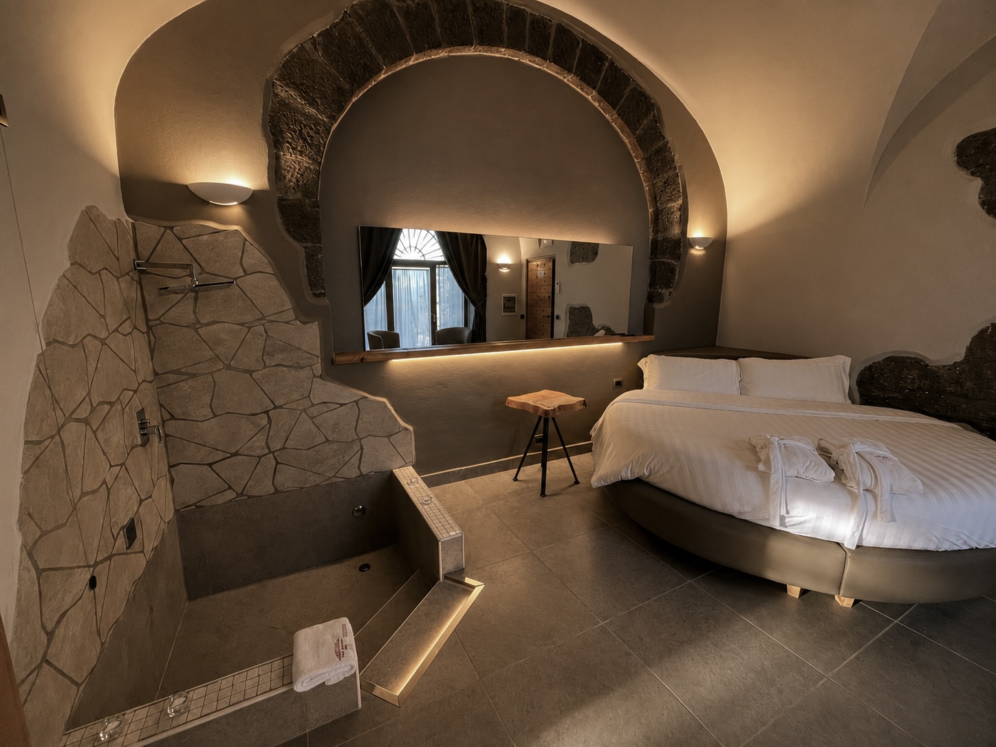 Suite con letto rotondo, arco in pietra e vasca